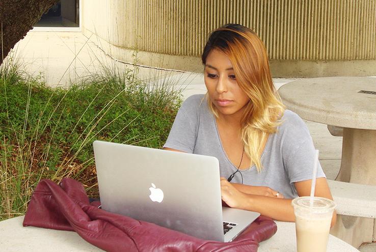 Woman sitting at a laptop outside